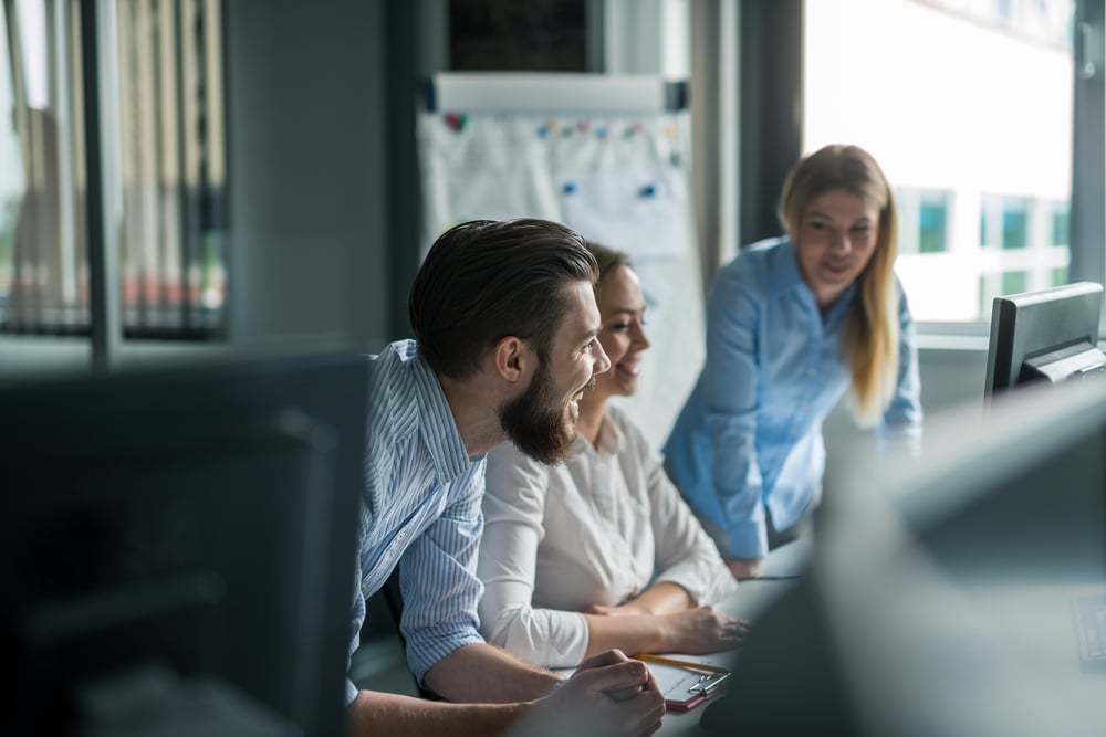 Arbeitskollegen im Gespräch vor einem PC